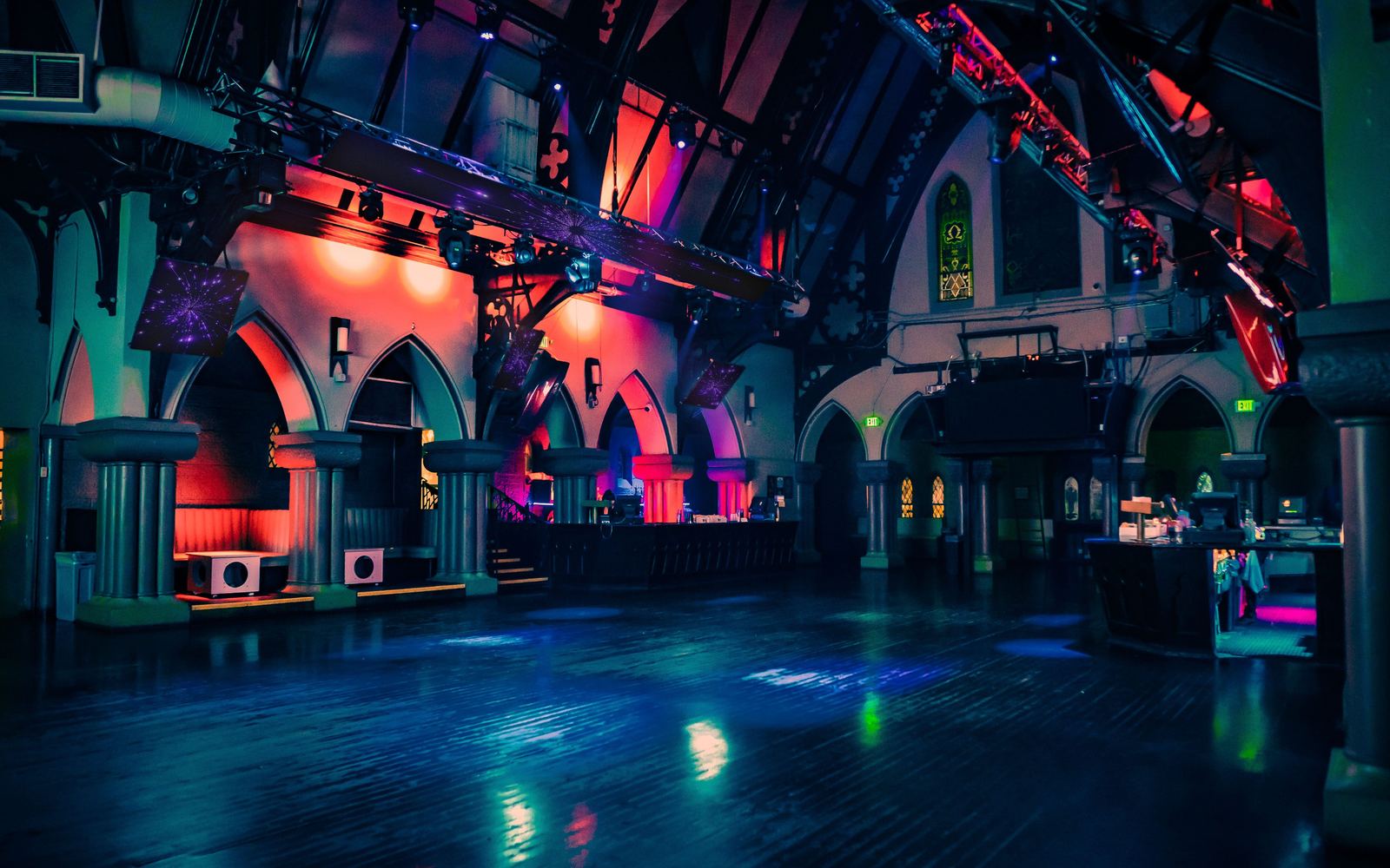 The main floor of The Church, gothic arches lit in red and blue.